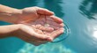 © Bima - Hands cupping clear water against a blurred blue background copy space