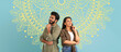 © Prostock-studio - Two young adults stand back to back while smiling. They have a light-hearted expression. The backdrop features a colorful, detailed design. The scene highlights friendship and joy.