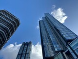 Skyscraper Perspective: An upward view of tall glass skyscrapers reaching toward a blue sky representing modern corporate architecture.