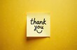 © Vadym - Yellow sticky note with handwritten thank you message and face. Simple graphic for expressing gratitude or appreciation in business or personal life.