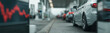 © pattozher - Traffic Congestion: A line of sleek cars waits patiently, the atmosphere charged with a hint of anticipation, juxtaposed against a digital display fluctuating, reflecting the economic pulse.