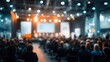 © IR-Creative - Audience attending a conference or presentation in a large auditorium with stage lights