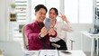 © Pichsakul - Asian adult professionals taking selfie with smartphone in modern office happy smiling cheerful coworkers enjoying break collaboration technology business environment