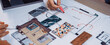 © InfiniteFlow - A hands-on planning session for home design showcasing a table filled with colorful samples, architectural drawings, and models to inspire innovative renovation ideas. SACTR