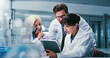 © peopleimages.com - Science, tablet and talking with people in laboratory together for development or research. App, feedback and teamwork with scientist group at work on clinical trial, medical industry or study
