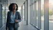 © aukkasit - Professional Businesswoman Walking Through Modern Office Building Hallway