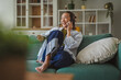 © Miljan Živković - Asian woman talking on smart phone smiling happily at home