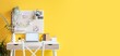 © Pixel-Shot - Workplace with laptop, blossoming tree branches and pegboard on yellow wall in room. Banner for design