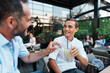 © Dusko - A happy father and his teenage son enjoy a refreshing drink while bonding at an outdoor cafe terrace during a summer afternoon.