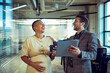 © Marko Geber - Colleagues laughing with pregnant coworker in modern office