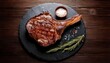© ARDHAN - Delicious Grilled Tomahawk Steak on a Slate Plate with Rosemary and Sea Salt.