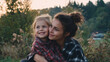 © Frank Gärtner - Mother and daughter embracing, sharing a loving moment outdoors, warm light falling on their happy faces