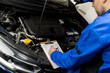 © zphoto83 - Car service technician inspecting engine and writing repair notes