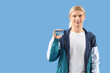 © Pixel-Shot - Young man with driving license on blue background