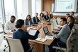 © Rohan Katwe - businesswoman Leading Boardroom Meeting. diverse boardroom team seated around long conference table, with laptops and notebooks open, discussing charts on screen in bright modern office environment.