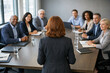 © Rohan Katwe - A diverse group of professionals engage in a meeting around a wooden table, fostering collaboration and problem-solving in a corporate setting.
