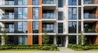 © Chandara - A modern apartment building with white and wood paneling, featuring large glass windows and balconies, with a landscaped front yard and greenery.