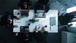 © InfiniteFlow - Top view of smart diverse team walk at meeting table and start to discuss about financial statistic. Group of business people prepare for meeting while looking at stock market document. Directorate.