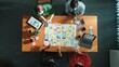 © InfiniteFlow - Top view of skilled team putting hand together to celebrate at meeting table while brainstorm idea about Ux, Ui design for mobile phone interface or designing application at meeting room. Convocation.