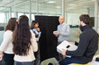 © Westend61 - Office team collaborating with employee presenting solar panel battery