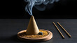 © Cynthia - Burning cone incense on wooden holder on dark surface