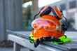 © vadish - Construction safety helmet with protective goggles, gloves and reflective vest on industrial site. Concept of workplace safety, protective equipment, construction industry and labor protection.