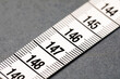 © New Africa - One measuring tape on grey background, closeup