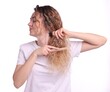 © New Africa - Unhappy woman trying to brush her tangled hair on white background