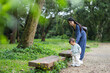 © leungchopan - Mother holding baby walking through forest in park