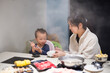 © leungchopan - Mother and baby sharing delicious hotpot together