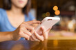 © leungchopan - Female customer browsing smartphone while sitting in restaurant
