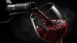 A side view of a dark wine bottle pouring red wine into a crystal glass, black background. Tasting, alcoholic beverage, drink.