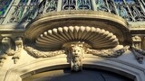 Mascaron beneath shell cornice on historic stone facade