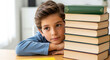 © Aleksandra - Young boy studying at home with stacked books on table