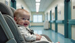 © KIRA POSLAVSKAIA - Smiling baby in car seat in hospital corridor after birth