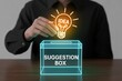 © ART BY SAIFUL - Business person putting a glowing lightbulb idea into a digital suggestion box