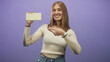 © Krakenimages.com - Young woman holding white chocolate bar points finger toward camera in studio; playful product promotion campaign.