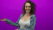 © Krakenimages.com - Woman smiling and presenting with palms up, showing chest and hands in purple studio wearing patterned shirt and white tank top; friendly welcome.