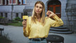© Krakenimages.com - Blonde woman reporter holding microphone with yellow flag shows thumbs down outside building steps and entrance; public disapproval.