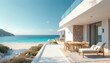 © miss irine - Modern white villa on sea coast with beach view. Outdoor dining set chaise lounge on patio terrace. Blue ocean water sky and distant hill. Peaceful sunny day at luxury resort.