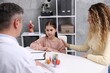 © New Africa - Endocrinologist consulting woman with her daughter at white desk in clinic