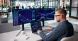 © Andrey Popov - Dedicated Stock Trader Monitoring Market Trends Across Several