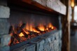 © maria_lh - A modern electric fireplace with a warm glow set in a stone wall. Rustic wooden mantelpiece in a cozy home interior design