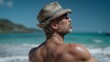 © Nataliia_Trushchenko - Male figure with short gray hair wearing a straw hat gazes towards the ocean, showcasing a muscular back against a tropical beach backdrop with clear blue water