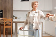 © Pixel-Shot - Mature woman with walker and her daughter holding hands in kitchen