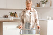 © Pixel-Shot - Mature woman using walker in kitchen