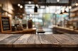 © Qori - Rustic wooden table with blurred cafe background for product display.