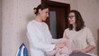 © Aliaksandr - Two women sharing a joyful moment while folding clean laundry at home, collaborating on household chores and domestic tasks with an iron visible on an ironing board