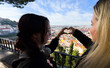 © Angelov - love Lisbon I love Portugal. Portugal. Lisbon. A girl holds hands in the shape of a heart on the background of of Lisboa, Portugal.