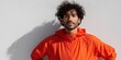 © Andrii Zastrozhnov - Closeup hispanic adult male wearing bright orange hooded windbreaker jacket against white wall facing camera confident expression